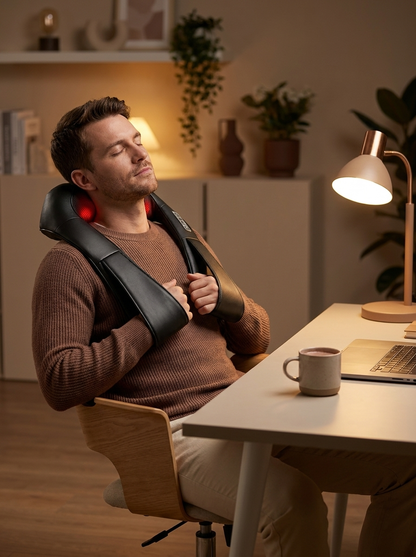 Unwinding at a home office desk wearing the ComfortWave massager
